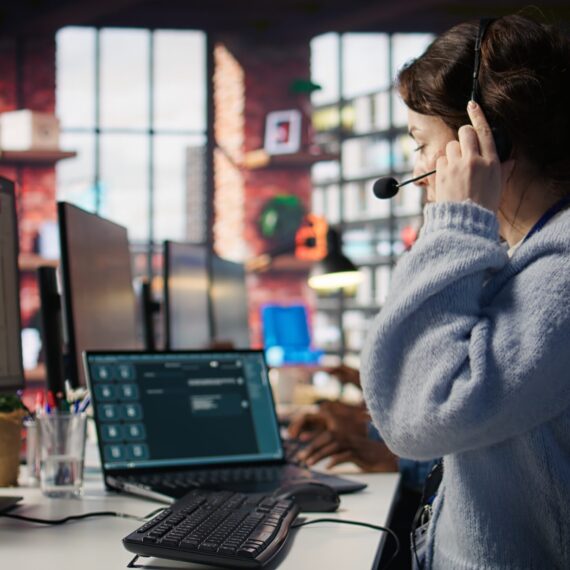 Customer support agent arriving at work, entering office, assisting customers with inquiries. Call center employee sitting down at PC desk, starting account management tasks, camera B